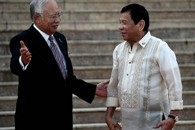 Malaysia's PM Najib (left) welcoming visiting Philippine President Duterte in Putrajaya yesterday. Mr Najib told reporters that on the issue of Sabah, the Philippines' claim "will not be addressed immediately".