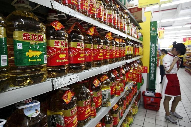 Edible oils sold under Wilmar's Arawana brand lining shelves at a Shanghai supermarket. A sturdy showing by the tropical oils segment as well as the oilseeds and grains segment boosted group revenues in the third quarter.