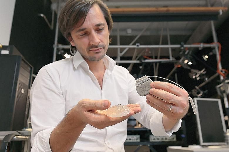 Prof Courtine with a silicon model of a primate's brain, a microelectrode array and a pulse generator. He hopes the new system can be transferred "in the next 10 years" to humans for therapy that would aid in rehabilitation and "improve recovery and 