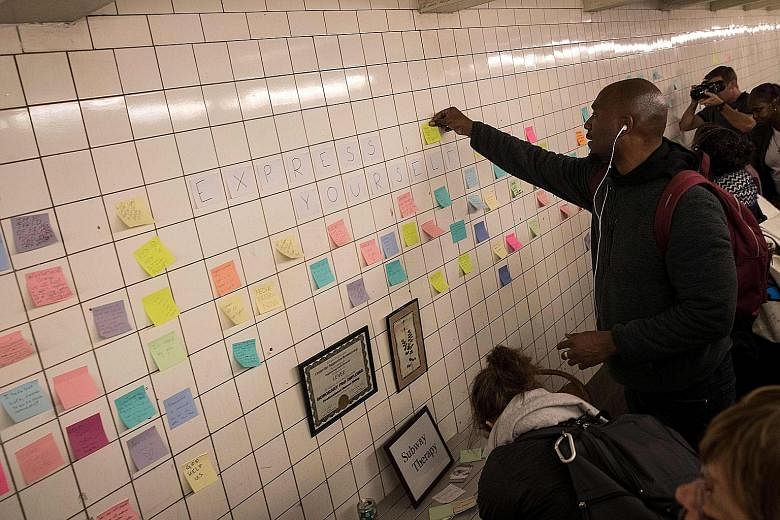 Commuters using Post-it notes to share their thoughts and pen messages, many of which were politically themed, in New York City's Sixth Avenue subway station on Thursday, as part of a public art project called Subway Therapy. Artist Matthew Chavez cr