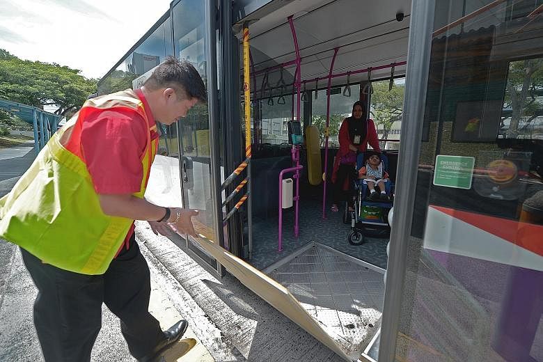 A bus captain opening the ramp of his bus for a passenger. As of October, about 91 per cent of the 5,330 public buses have manual ramps. Bus captains have to get out of their cabins to open the ramp, which is on the floorboard at the rear door.