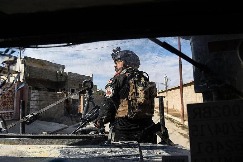 A member of the Iraqi forces patrolling a village at Mosul's edge, as clashes go on between the Iraqi military and ISIS.