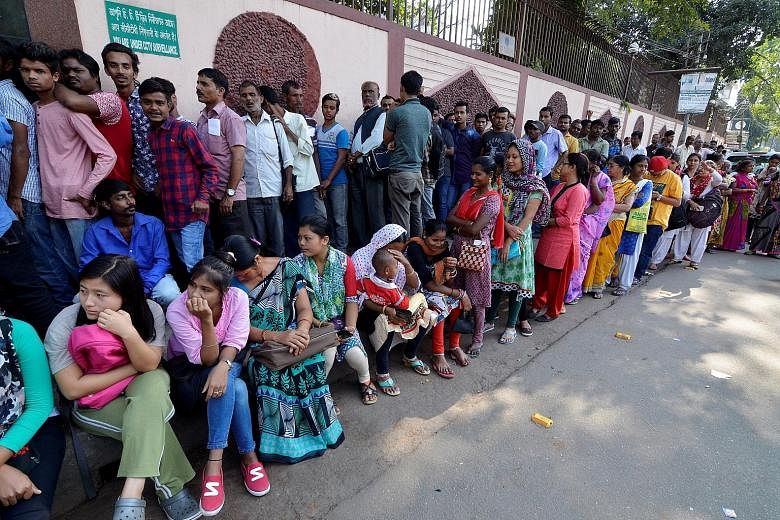 Indians waiting in queue outside a bank in Guwahati yesterday to exchange 500- and 1,000-rupee notes that were taken out of circulation last week in a shock move aimed at uncovering unaccounted wealth hidden from the taxman.