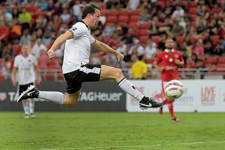 Germany's Fredi Bobic is airborne while scoring one of his two goals at the National Stadium yesterday. "We are a little bit older, not so fast any more, but there's a lot of passion in the game," he said of the Masters clash. The England veterans wo