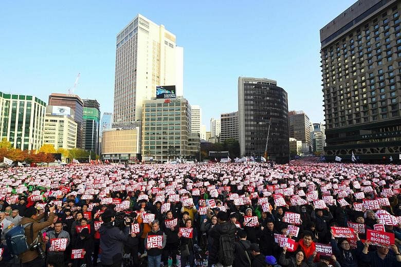 Hundreds of thousands of protesters holding signs on the streets of Seoul yesterday demanding that South Korean President Park Geun Hye step down.