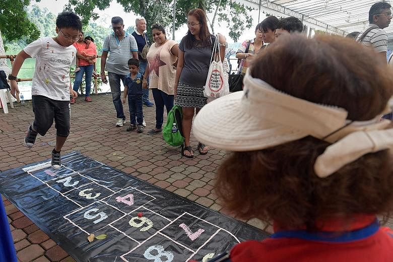 Permanent resident Kevin Lin Thant Zin (left), 10, playing a game of hopscotch at the Singapore Zoo, during an event aiming to foster ties between Singaporeans, permanent residents and foreigners.