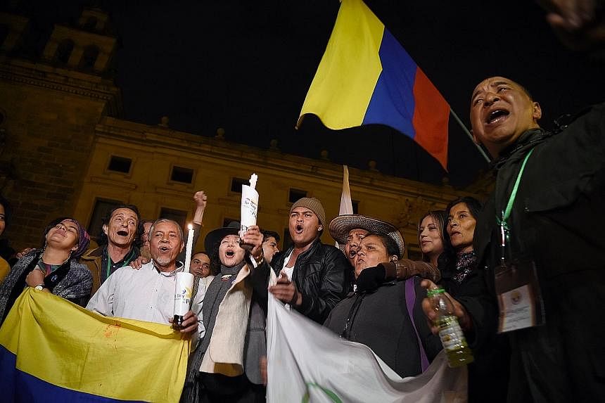 People celebrating in Bogota after the Colombian government and Marxist Farc rebels signed a modified peace deal to end 52 years of civil war.