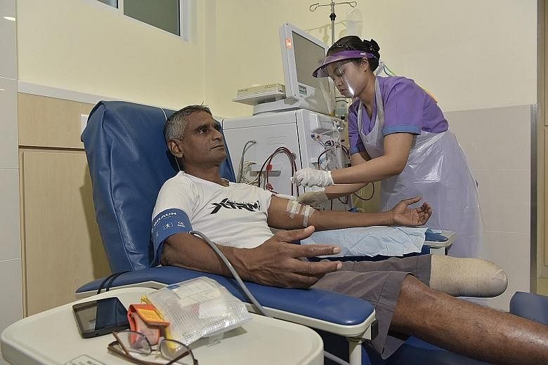 Staff nurse Nur Asiah, 27, preparing Mr Shanmuganathan for his kidney dialysis treatment.