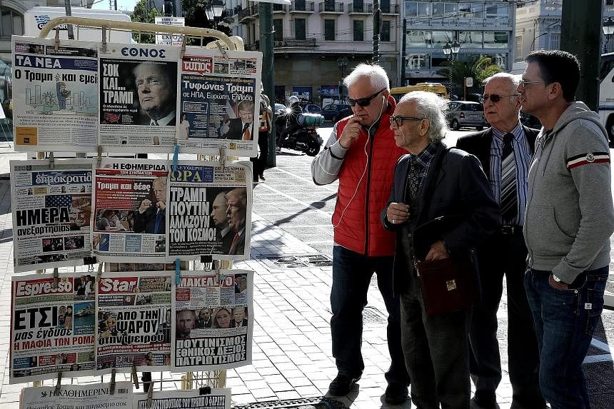 People in the Greek capital Athens reading the front pages of newspapers featuring the election of Mr Donald Trump as the next US president.