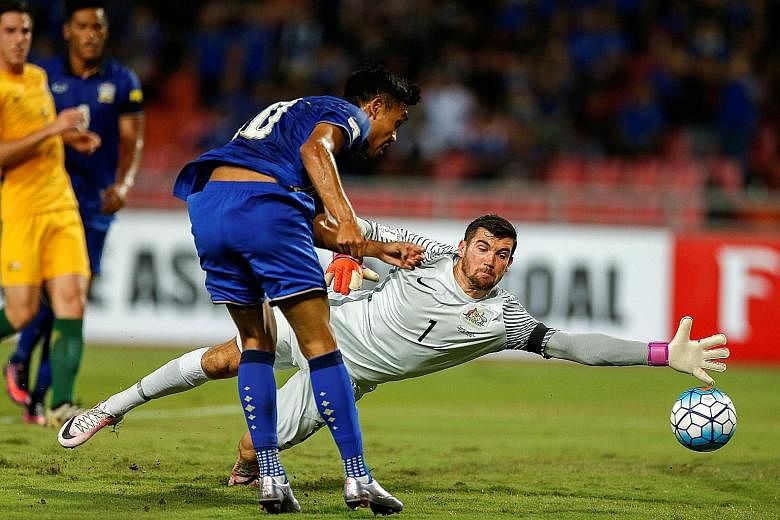 Teerasil Dangda scoring past Australia goalkeeper Mathew Ryan to put Thailand level 1-1 at the Rajamangala National Stadium in Bangkok. The 2-2 result means the Socceroos fall out of the automatic qualifying spots.