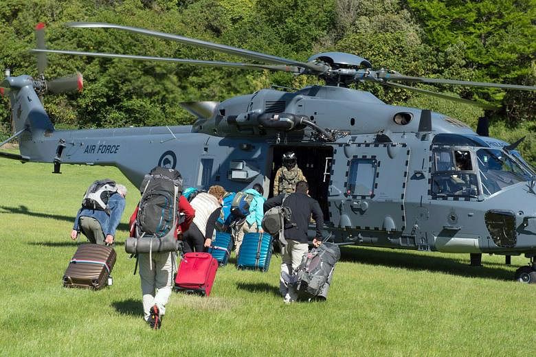 Some of the 1,200 tourists stranded by the earthquake in Kaikoura being evacuated by a New Zealand Defence Force helicopter yesterday. Due to the quake, huge landslides have cut road and rail links to the town, where police say water is running low, power