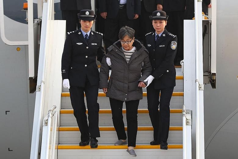 Ms Yang Xiuzhu disembarking from a plane in Beijing after returning from the US yesterday. She had fled China in 2003 after the authorities began investigating her alleged involvement in criminal activities.
