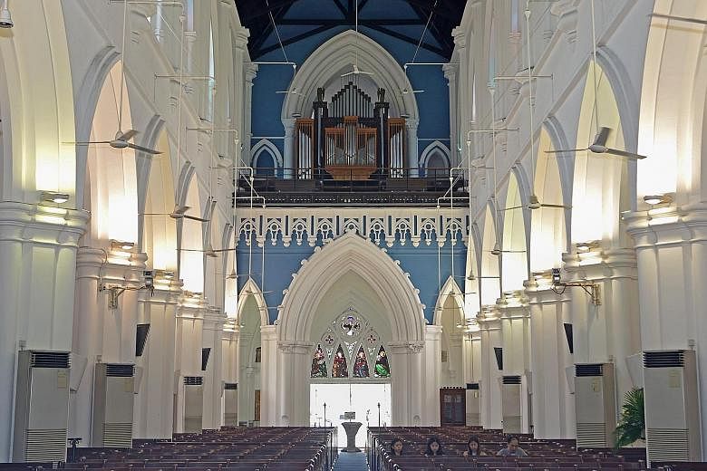 From the inside of St Andrew's Cathedral, facing the back, one can see the pipe organ at the top, with stained glass panels below depicting the biblical figures Matthew, Mark, Luke and John.