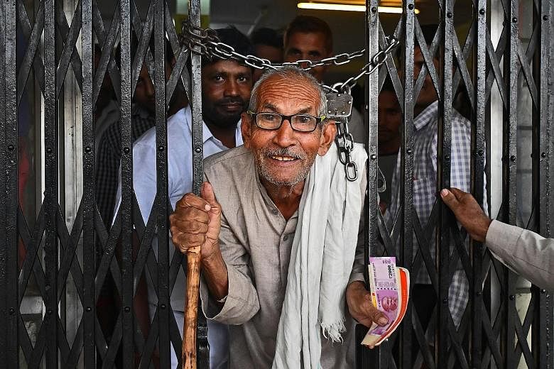 A farmer leaving a bank in Uttar Pradesh with a new 2,000-rupee banknote.