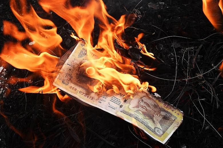 Activists burning a poster of a 500-rupee note during a protest rally against Indian Prime Minister Narendra Modi in Kolkata on Monday, as frustration mounts over the chaos caused by the government's sudden and unexpected demonetisation move.