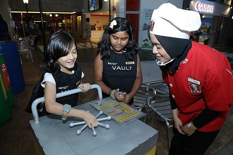 Elie Nur Aisha Johari (left) and Arun Thirral Amiltham Alarmugill at the KidZania Singapore party. Kids also learnt about managing money at the Maybank-sponsored event.