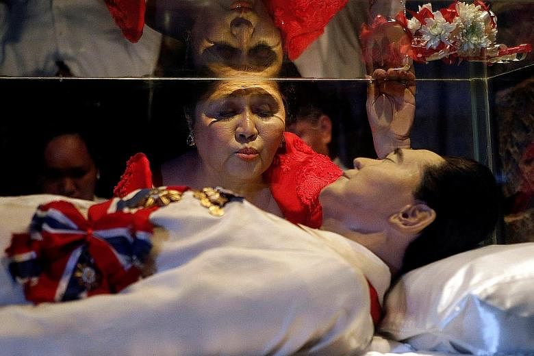 Former first lady Imelda Marcos kissing the glass coffin of her husband Ferdinand Marcos during her 85th birthday celebrations in July 2014 in his hometown of Batac, Ilocos Norte province, in the northern Philippines.