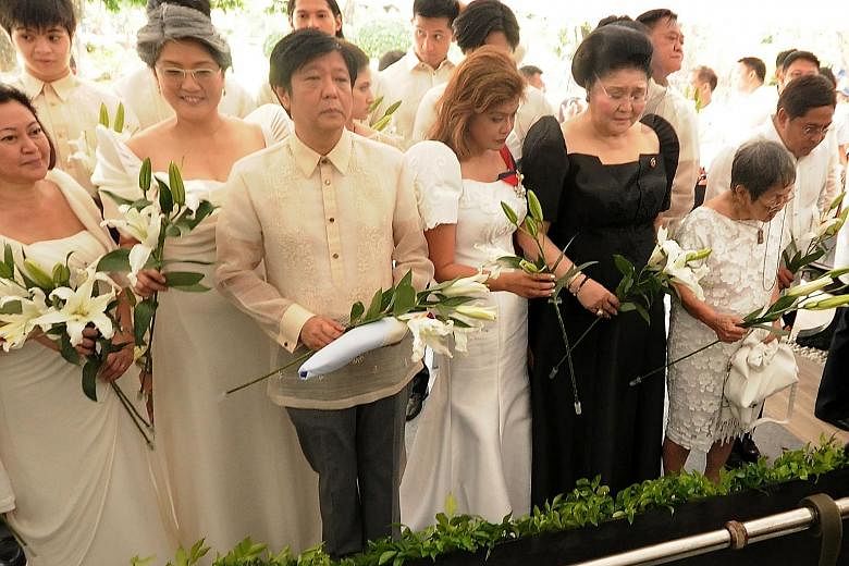 Left: Mrs Marcos (in black) attending Mr Marcos' burial at the National Heroes' Cemetery in Manila yesterday. With her are their son Ferdinand Marcos Jr and daughters Imee (fourth from right) and Irene (second from left). The burial came less than 10