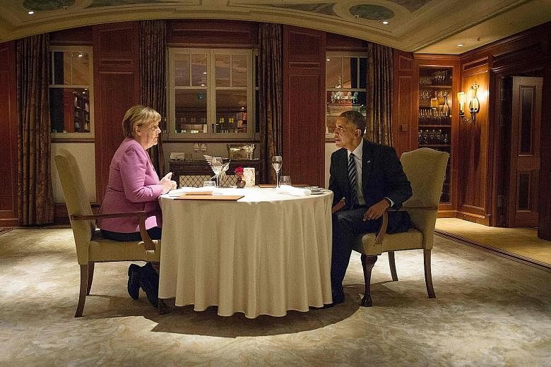 Dr Merkel and Mr Obama having dinner at the Hotel Adlon in Berlin on Wednesday. Giving a ringing endorsement for the German Chancellor before she announces whether she will run for a fourth term in next year's elections, Mr Obama acknowledged the bur