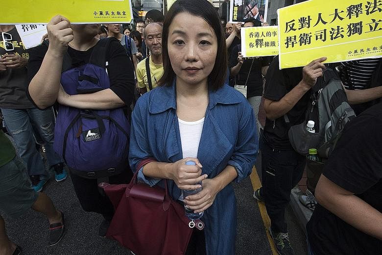 Ms Lau at a march this month to protest against Beijing's interpretation of Hong Kong's Basic Law over oath-taking in the legislature. The bid to unseat her failed because of delays in the application.