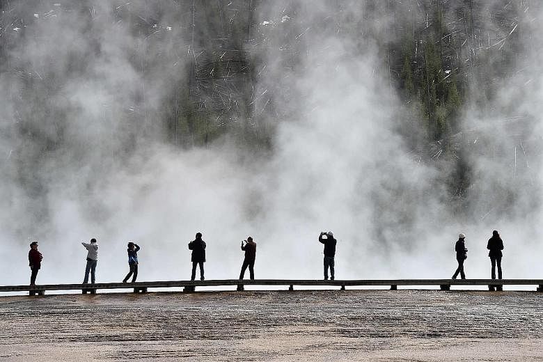 Tourists at the Grand Prismatic Spring in Yellowstone National Park. Visitors have been warned not to stray beyond the park's official paths as much of its wilderness remains untouched.