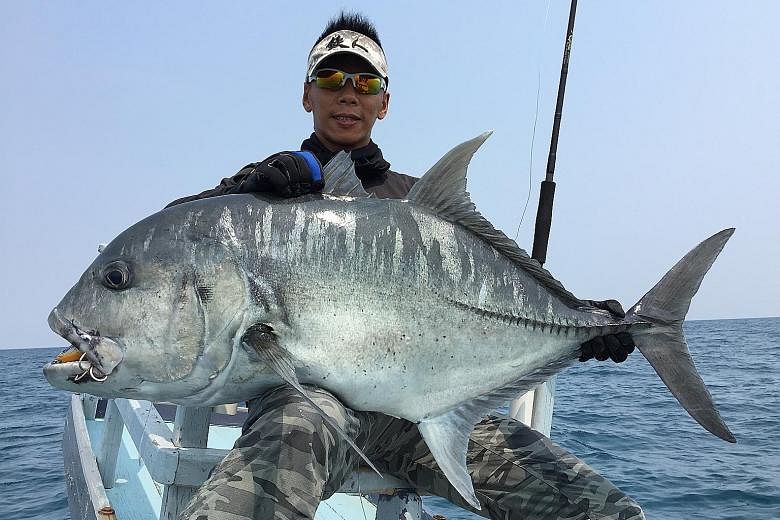 Mr Ivan Goh, chief guide of Deep Sea Fishing, with a giant trevally caught last year in East Kalimantan, Indonesia. He said the company has stopped making trips to Indonesian waters where the anglers were arrested as a "precaution".