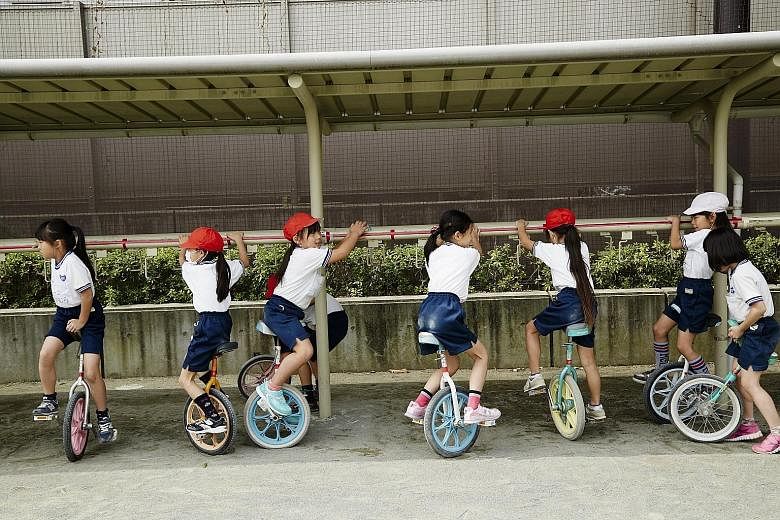 Children at Kyuden Elementary School riding unicycles during recess. It is part of a culture that urges elementary school children to do things on their own, including taking the subway or walking around city neighbourhoods