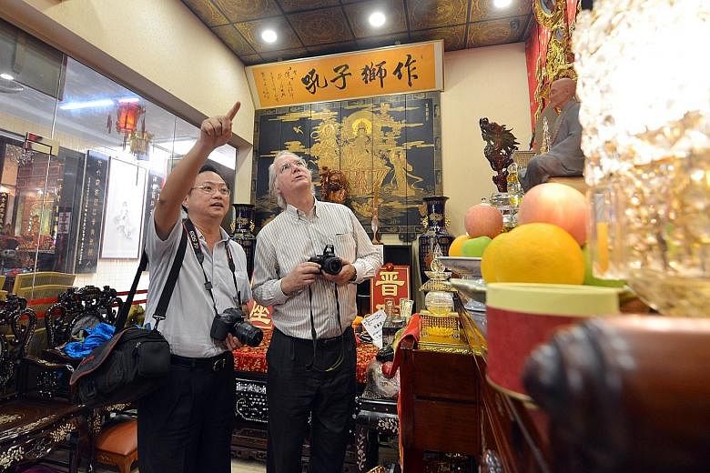 Professor Dean (left) and Dr Hue (far left), seen here at Leong San See Temple in Race Course Road, have been recording, photographing, analysing and translating Chinese inscriptions into English from 63 Buddhist and Taoist temples, clans and guild h