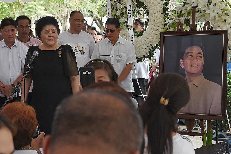 Former first lady Imelda Marcos (in black) speaking to supporters at the grave of her husband, the late dictator Ferdinand Marcos, at the national heroes' cemetery in Manila yesterday, a day after the controversial burial took place.