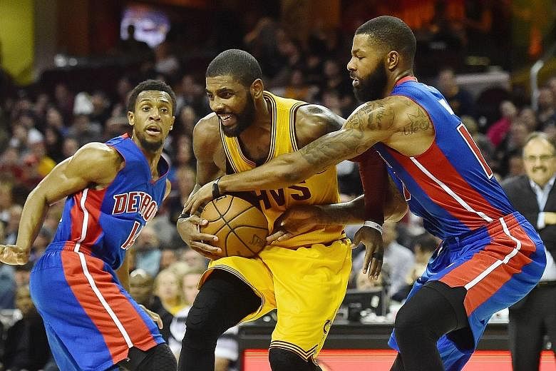 Detroit's Marcus Morris (far right) trying to strip Cleveland's Kyrie Irving of the ball as Ish Smith watches at Quicken Loans Arena. Irving led the hosts with 25 points as they won the National Basketball Association game 104-81.