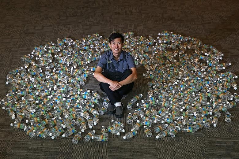 Environmentalist Tan Hang Chong surrounded by 432 bottles of Newater, which is equivalent to 151 litres of water - the average water consumption of each person each day in Singapore last year.