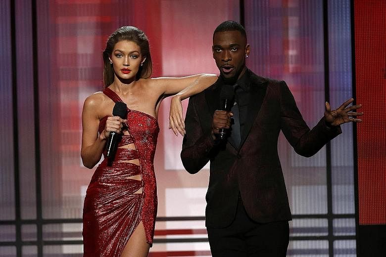Hosts of the American Music Awards Gigi Hadid and Jay Pharoah (both above) took a dig at President-elect Donald Trump and his wife Melania while Green Day's frontman Billie Joe Armstrong slammed Mr Trump during the band's performance.