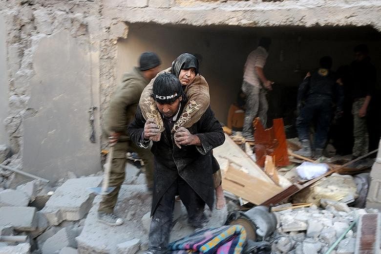 A woman being rescued from the rubble of a building following reported air strikes on Aleppo's rebel-held district of al-Hamra on Sunday.