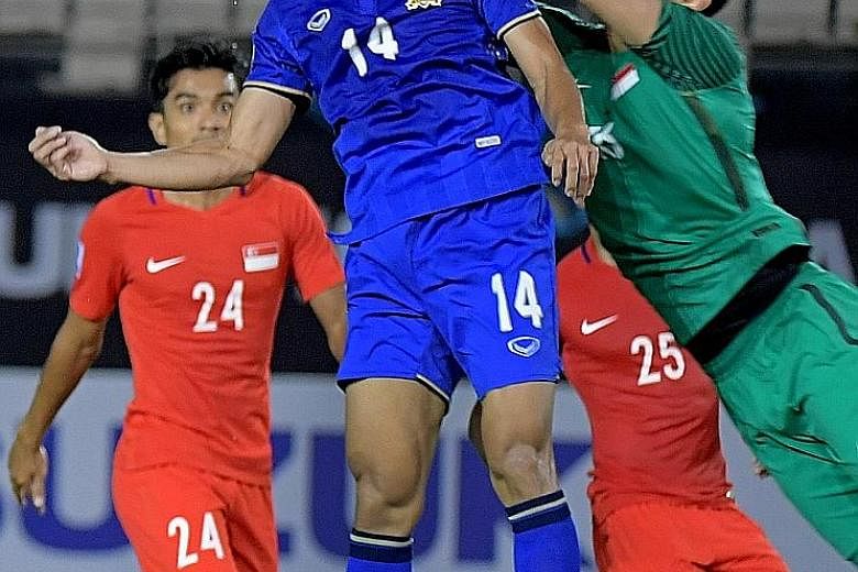 Thailand's Sarawut Masuk (No. 14) celebrating his winning goal with his skipper Teerasil Dangda after leaping the highest to head the game's only goal past Singapore goalkeeper Hassan Sunny.