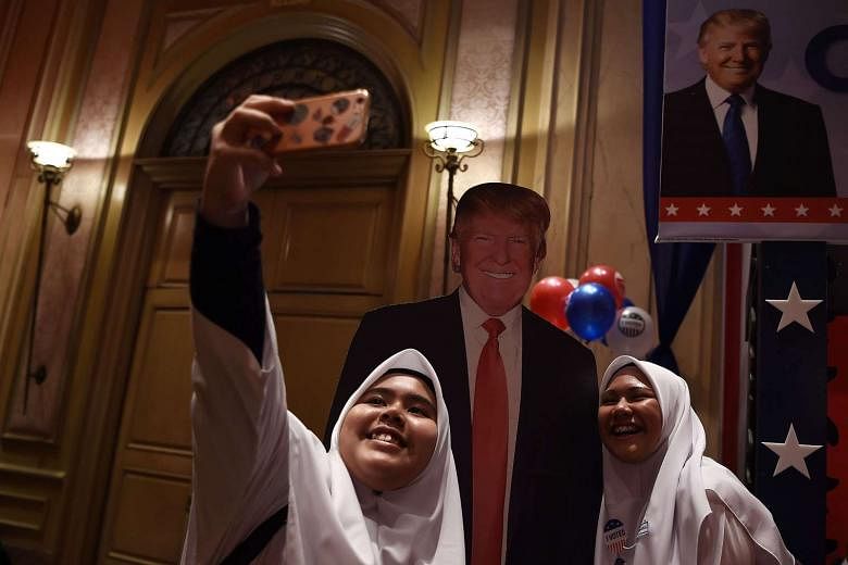 Malaysian Muslim schoolgirls taking a selfie with a cut-out of Mr Trump. Malaysia's best hope is that the incoming US President's anti-Muslim campaign rhetoric does not translate into official policy. 