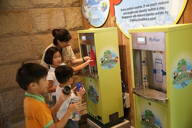 "Ranger Ooz", Singapore Zoo's advocate for reducing waste, guides pre-school children as they refill their water bottles at the water dispenser developed by Hyflux.