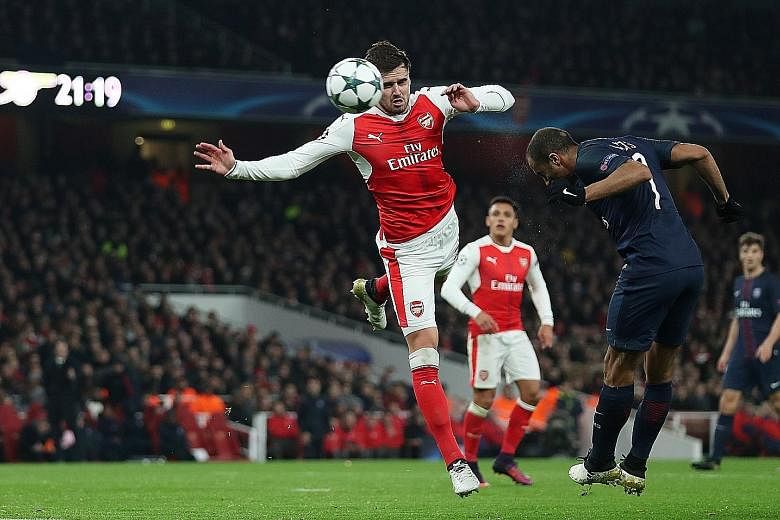 PSG's Brazilian midfielder Lucas Moura (right) heading the ball, which was deflected into the Arsenal net by Alex Iwobi (not pictured) for their equaliser in the 2-2 draw at the Emirates Stadium on Wednesday. The French champions can ensure top place
