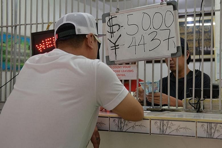 A moneychanger in Manila. The peso fell to its lowest level against the dollar in eight years yesterday.
