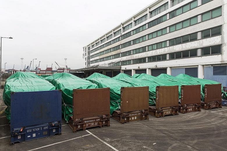 The armoured vehicles covered with green tarpaulins in a Hong Kong Customs and Excise Department facility in Tuen Mun yesterday. Nine Terrex Infantry Carrier Vehicles were seized by Hong Kong Customs at a port on Wednesday. They were being shipped fr
