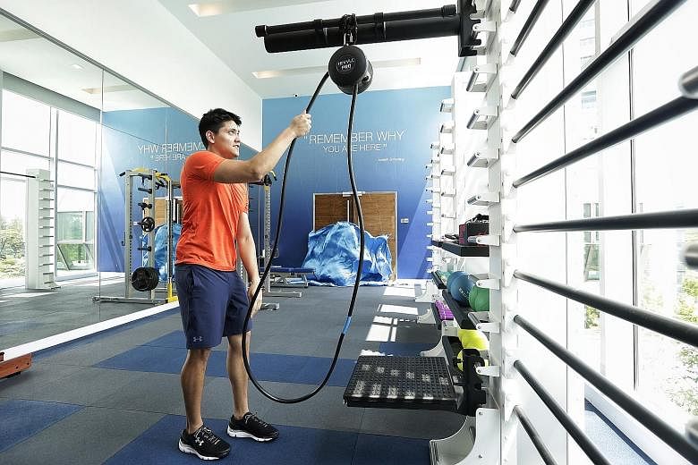 Joseph Schooling using the rope resistance trainer in the new sports gym at the Chinese Swimming Club yesterday. The message "Remember why you are here" on the gym wall repeats the phrase displayed in Schooling's apartment in Austin, Texas.