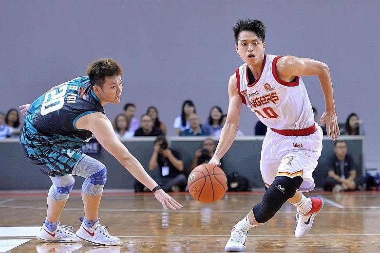 Singapore Slingers forward Leon Kwek (right) dribbling past Loh Shee Fai of the Westports Malaysia Dragons during the home team's 80-62 win at the OCBC Arena yesterday.