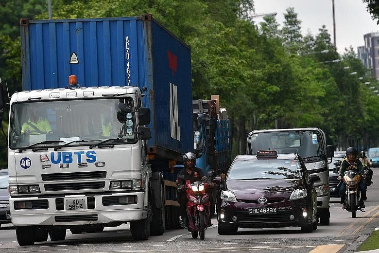 A motorcyclist riding closely to a heavy vehicle in Woodlands Avenue 12 yesterday. Being more exposed than other motorists makes motorbike riders the most vulnerable road users, with 4,875 motorcyclists and their pillion riders injured last year, a 5