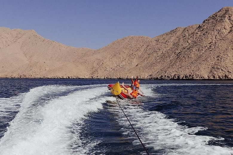 Boys on a towed water sled in a cove in Oman's isolated Musandam Peninsula. Off-the-beaten- path Oman has seen a surge in tourism.