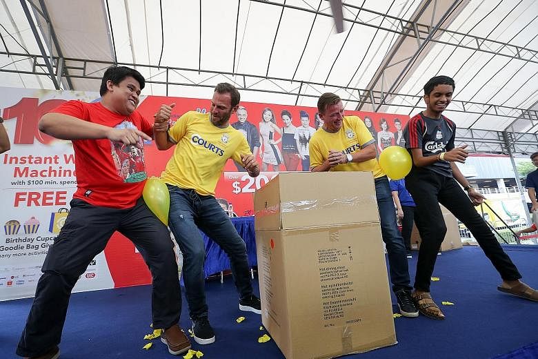 Retired Liverpool players Patrik Berger (second from left) and Vladimir Smicer showing they are good Czech-mates with fans, in a game to burst balloons at a meet-and-greet session at Courts Megastore.