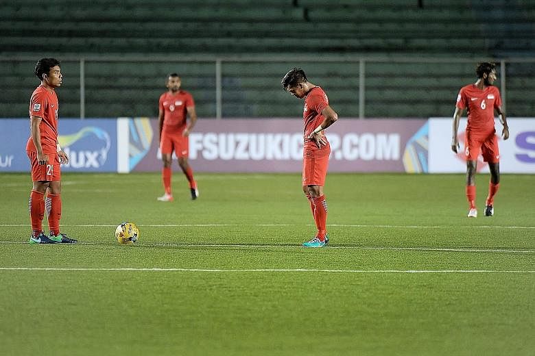 Singapore's Shahfiq Ghani (left) and Khairul Amri looking dejected after Indonesia scored their second goal in the final Suzuki Cup Group A match which ended 2-1.