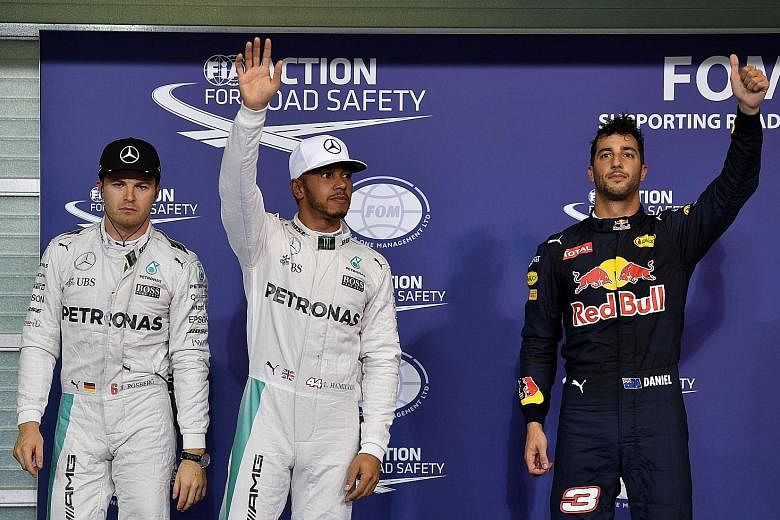 Their facial expressions could not be more stark. Mercedes' British driver Lewis Hamilton acknowledges the fans' cheers after winning pole position for the Abu Dhabi Grand Prix, while his German team-mate and championship leader Nico Rosberg looks gl