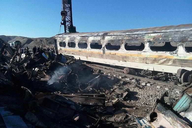 A destroyed train coach smouldering where two trains collided near the Iranian city of Shahroud on Friday. At least 44 people have died, with dozens more injured in one of Iran's worst rail disasters.