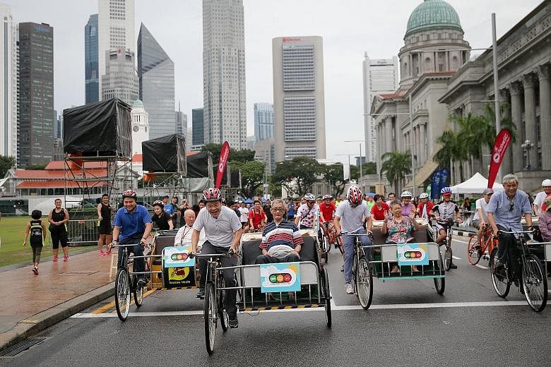 National Development Minister Lawrence Wong kicking off the trishaw ride by giving Sasco Senior Citizens' Home resident Tan Jin Kiat a lift on Car-Free Sunday yesterday. Six trishaws were introduced at the event to cater to the less mobile. WATCH THE