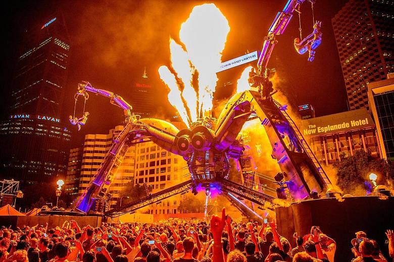 Spectators watching Aboriginal dancers and acrobats performing with a 50-tonne mechanical spider - constructed from repurposed military hardware - in a series of laser and pyrotechnics shows by Arcadia in Perth, Australia, over the weekend.