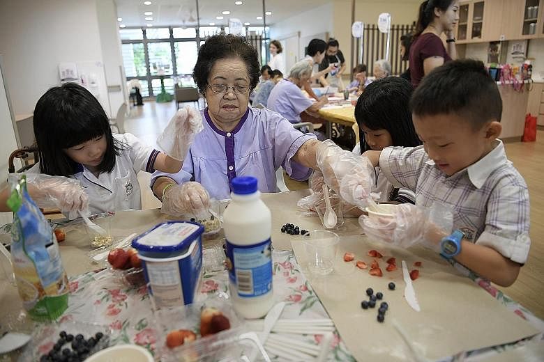 Madam Oh Quee Eng, 80, making yogurt treats with children at Yishun Community Hospital. Health Minister Gan Kim Yong, who officially opened the hospital yesterday, said community hospitals can "help patients improve their functions and regain confide
